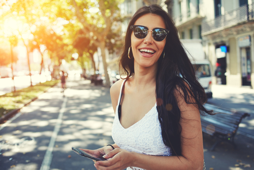 Lady with white blouse and sunglasses looking at camera. 