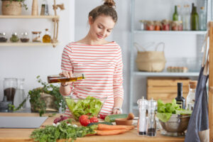 girl putting olive oil on salad 