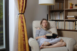 Girl reading book in chair 