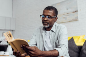 man reading book at home