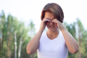 woman rubbing eyes from fireworks 