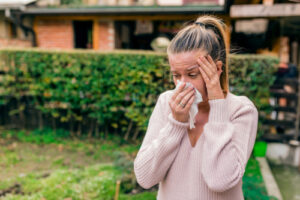 woman wiping eyes from allergies 