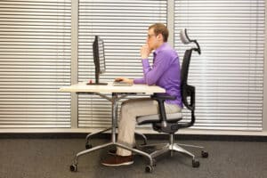 man using computer while wearing blue light eyeglasses